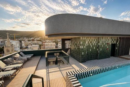 a building with a swimming pool on top of a building at High-Floor Modern Apartment - Rooftop Pool & Table Mountain Views in Cape Town
