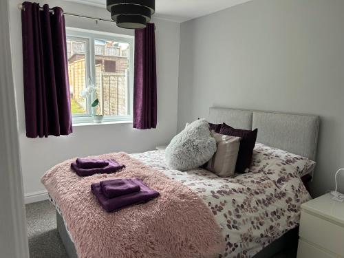a bedroom with a bed with purple towels on it at Captivating 1-Bed Apartment in Hednesford in Cannock