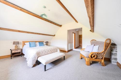 a bedroom with a king sized bed and a chair at The Barn in Corwen
