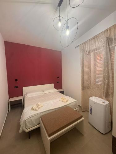 a bedroom with two beds and a red wall at B&b Al Castello in Gerace