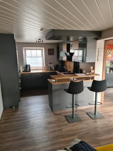 a kitchen with two black stools in a room at Ferienwohnung Grahn 15154 in Leer