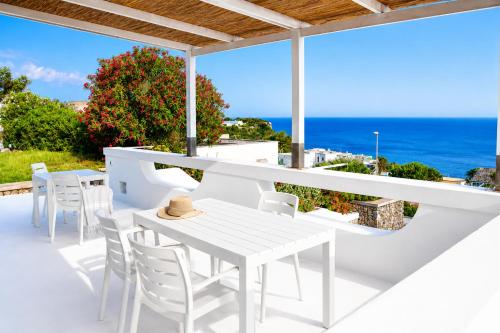 a white table and chairs on a balcony with the ocean at Maridea - Ondine in Ponza