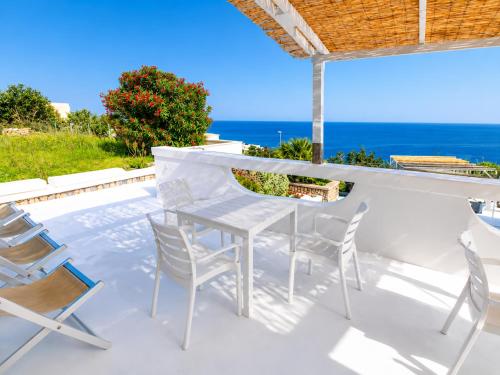 a white table and chairs on a patio with the ocean at Maridea - Ondine in Ponza