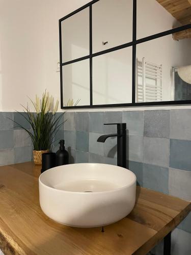 a white sink on a wooden counter in a bathroom at El Rincón de la Plazuela in Romancos