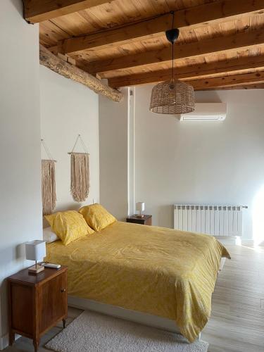 a bedroom with a large bed and a wooden ceiling at El Rincón de la Plazuela in Romancos