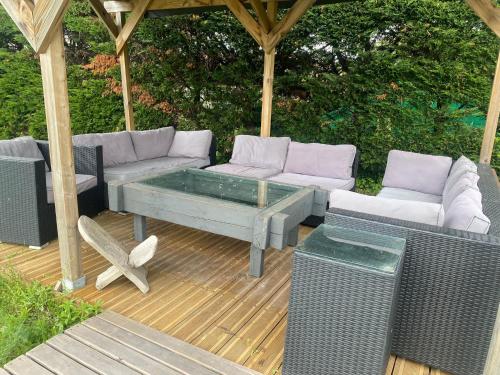 a patio with a couch and a table and chairs at Loue appartement avec jardin in Alba-la-Romaine