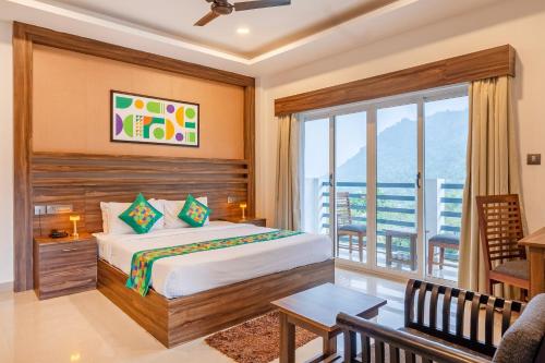 a bedroom with a bed and a balcony at Treebo Misty Garden Resort & Spa With Swimming Pool in Munnar