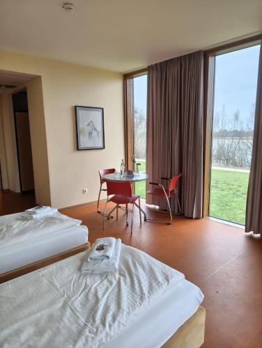 a hotel room with two beds and a table and chairs at DJH Jugendherberge Xanten in Xanten