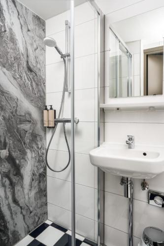 a bathroom with a sink and a shower at Hotel Damsquare in Amsterdam