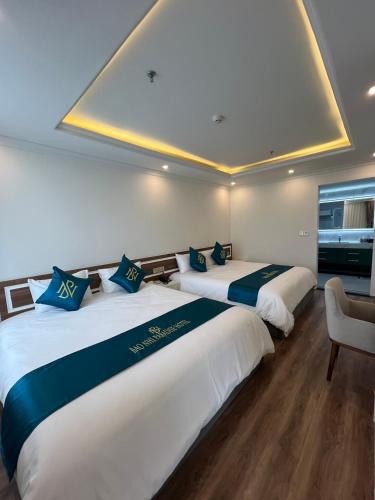 two beds in a hotel room with blue and white at Bảo Nhi Paradise Hotel in Làng Môn