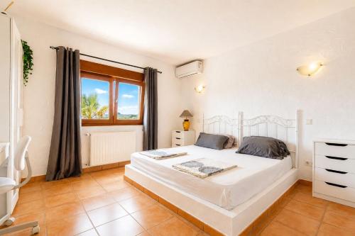 a bedroom with a white bed and a window at Cozy vacation home in Alfaz del Pi