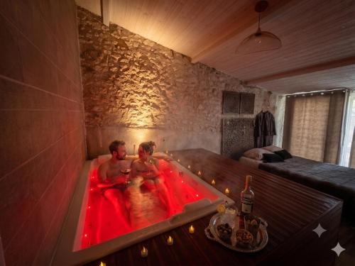 a man and woman in a hot tub in a room at Caporizon-Lov'BNB-La seule Love House de Dordogne in Biras