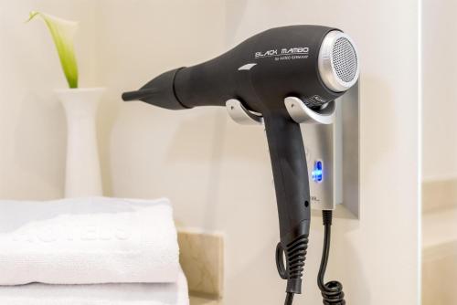 a black blow dryer is attached to a wall at NH Brussels EU Berlaymont in Brussels