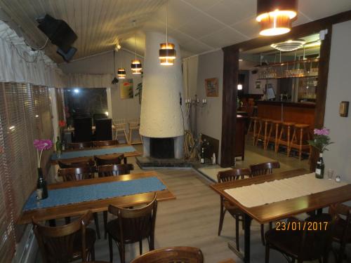 a restaurant with a fireplace and tables and chairs at Huoneistohotelli Jokikeskus in Kemi