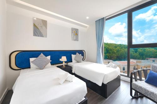 two beds in a room with a large window at Diamond Suite The Hill Phu Quoc in Phú Quốc