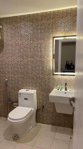 a bathroom with a toilet and a sink at Golden New Tulip in Abha