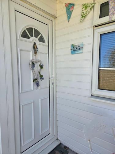 a white door with a sign on the side of a house at Seabiscuit in Scratby