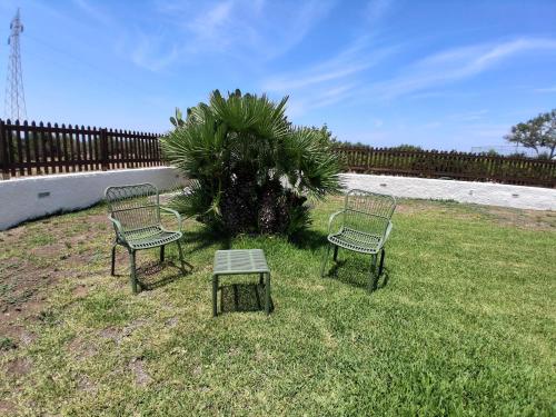 two chairs and a table in a yard with a fence at villa amodeo in Paceco