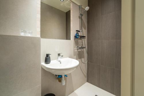 a bathroom with a sink and a shower at Øksfjord Hotel Norway in Øksfjord