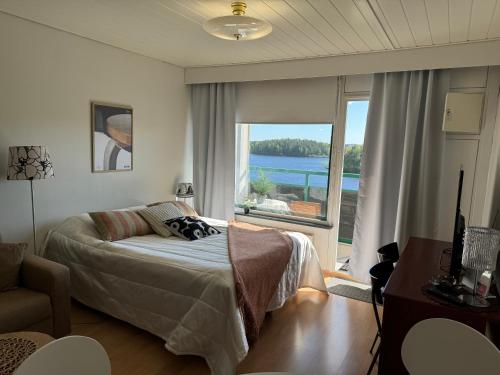 a bedroom with a bed and a view of the water at Hotelli Terme 614 in Ikaalinen
