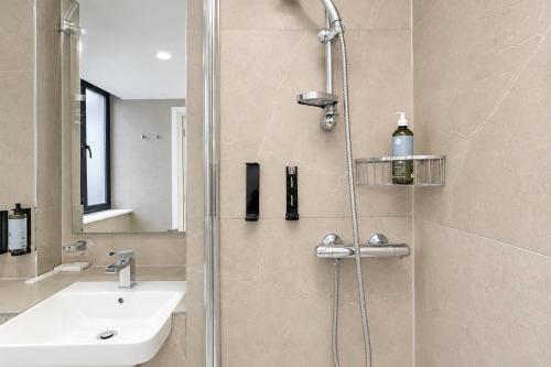 ein Badezimmer mit Dusche und Waschbecken in der Unterkunft The Manor Park Hotel in London