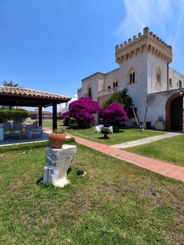 a building with a flower pot sitting in the grass at villa amodeo in Paceco