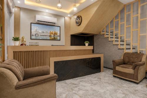 a lobby with a fireplace and two chairs and a staircase at Hotel The RG Grand Inn Near Chandigarh Railway Station in Chandīgarh