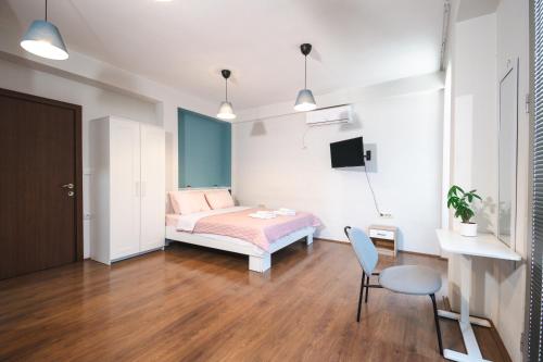 a bedroom with a bed and a table and a chair at White & Wood in Bitola