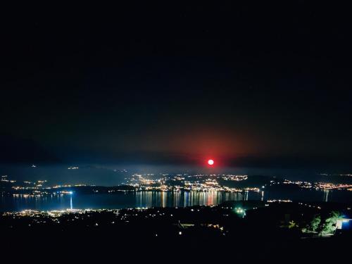 a view of a city at night with a red light at Tzaneta's star view in Kefallonia