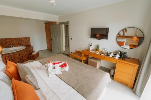 a bedroom with a bed and a sink and a mirror at Yalıpark Beach Hotel in Yalıkavak