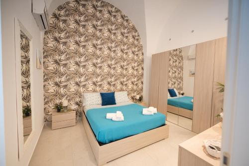 a small bedroom with a blue bed and a mirror at La VILLA in Modugno