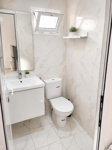 a white bathroom with a toilet and a sink at STUDIO FOR 3 PERSON & ANOTHER FOR 4 PERSON - MIRAMAR MARTIL ll in Martil