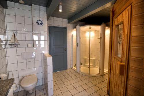 a bathroom with a toilet and a shower with a sink at Reethuus am Fething in Langeneß