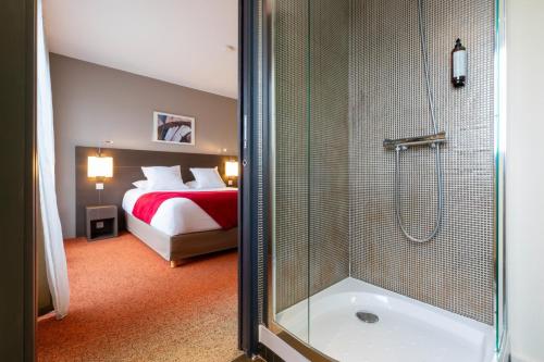 a bathroom with a shower and a bed and a tub at Appart Hôtel Clément Ader in Toulouse