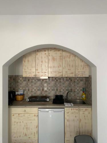 a kitchen with wooden cabinets and a sink at Kapares Studios & Apartments in Agia Anna Naxos