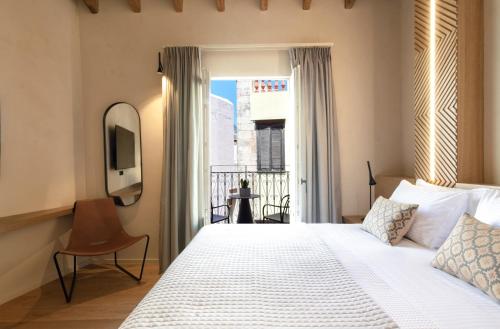 a bedroom with a white bed and a window at Consolato Boutique in Chania