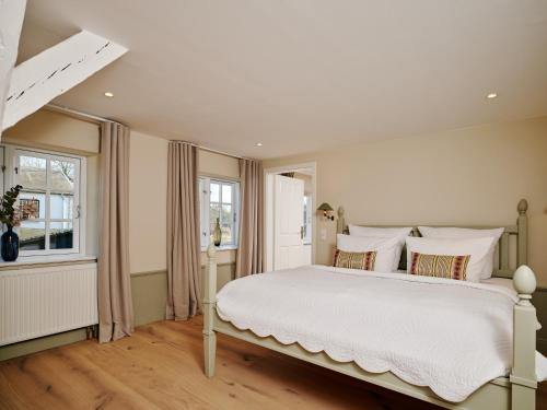 a bedroom with a large white bed and a window at Hotel & Restaurant Ole Liese in Panker