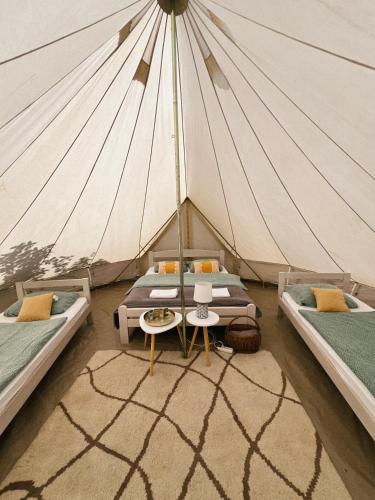 a tent with two beds and a table at Camp Oaza, Lipa in Cetinje