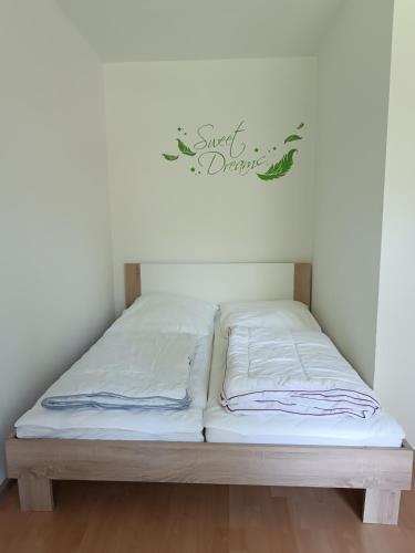 a bed in a room with a sign on the wall at Ferienwohnung Karl 54 in Gelenau