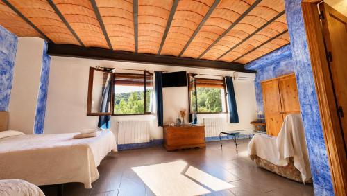a bedroom with a bed and two windows at Hotel Finca Aldabra in Pinos Genil
