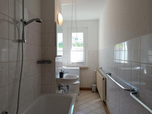 a bathroom with a tub and a sink and a shower at Ferienwohnung Karl 54 in Gelenau