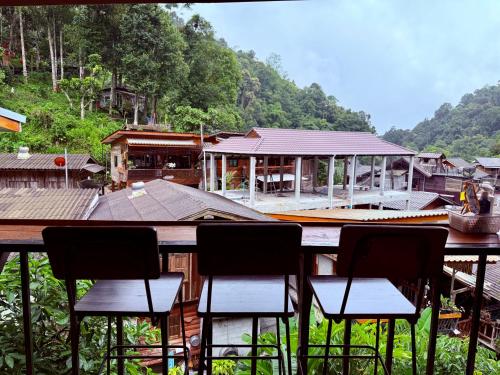 a group of chairs sitting in front of a building at กินลมชมจันทร์ แม่กำปอง in Ban Pok Nai