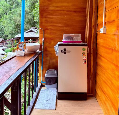an old refrigerator sitting on a porch at กินลมชมจันทร์ แม่กำปอง in Ban Pok Nai