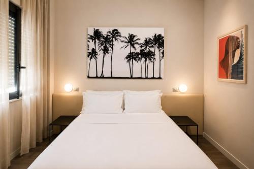 a bedroom with a white bed with palm trees at Hotel Salus in Pescara