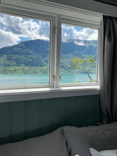 a bedroom with a window with a view of the ocean at Fjord House Hardanger in Grimo