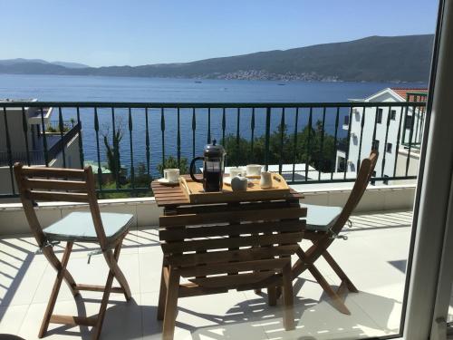 a table and chairs on a balcony with a view of the water at Adriadome Sky in Bijela