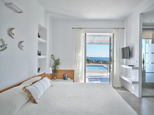a bedroom with a bed and a view of a pool at Blue Mare Villas in Naousa