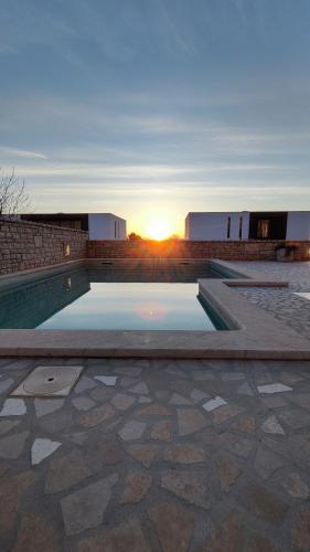 a swimming pool with the sunset in the background at Apartment Istra Mare private pool & parking in Ližnjan