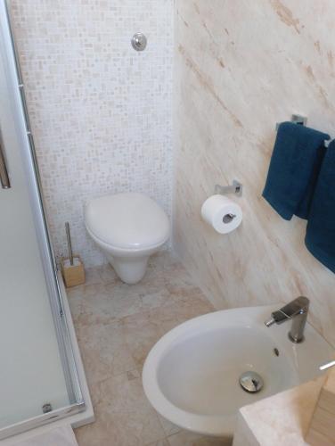 a white bathroom with a toilet and a sink at Finestre Sul Mare Salento - CasaVacanza in Punta Prosciutto