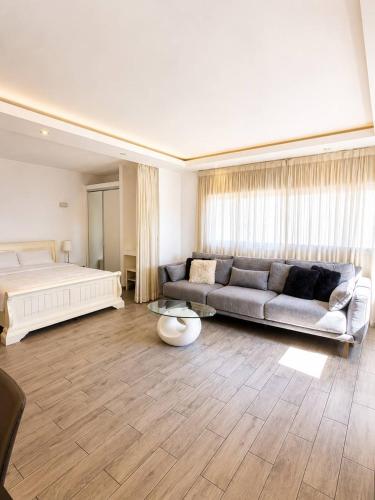 a large living room with a bed and a couch at Royal Lea Apartmens in Netanya